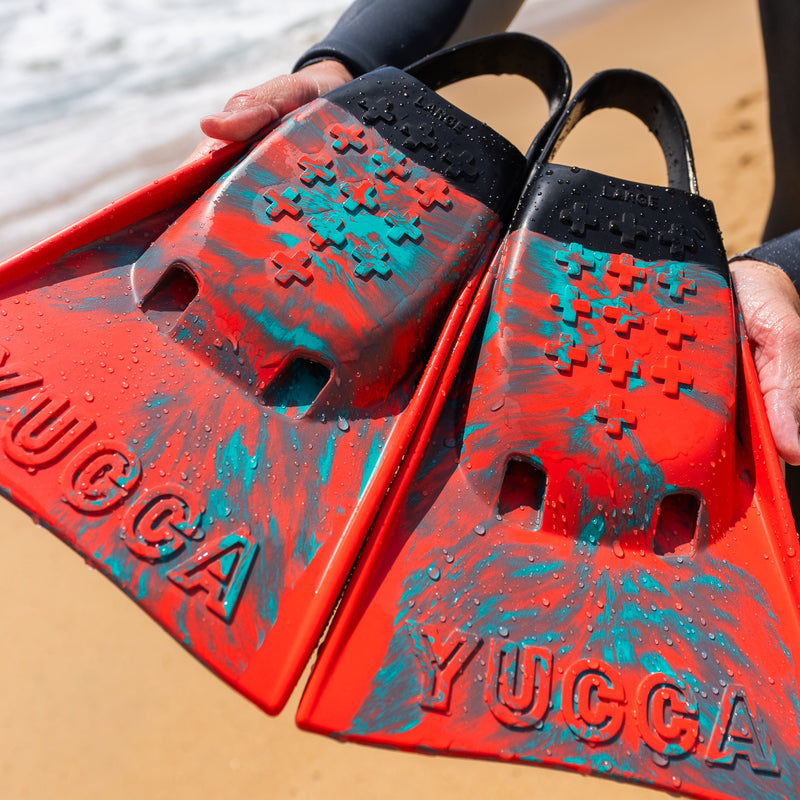 Yucca Sir Wiggins Short Blade Fins - Standard Flex - Yucca Fins swim fins held on a beach.