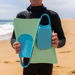 Person holding Yucca Karam Short Blade Fins - Soft Flex - Yucca Fins on a beach