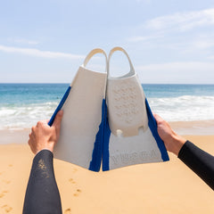 Person holding Yucca Glacier Scraps Short Blade Fins - Super Flex - Yucca Fins on a beach with ocean in the background
