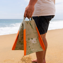 Person holding Yucca Primo Short Blade Fins - Super Flex - Yucca Fins on a beach