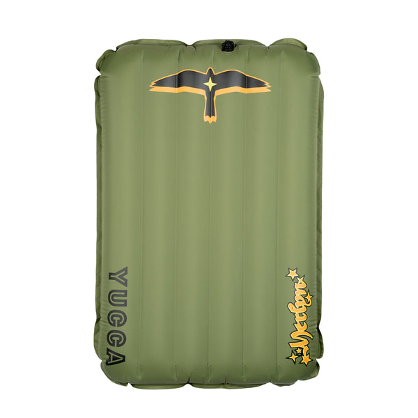 Olive green Yucca Junior Merlyn inflatable surf mat shown flat against a light gray background. Features vertical air chambers, black and gold bird logo at the top, black Yucca logo along the side, and yellow script Merlyn logo near the bottom. 