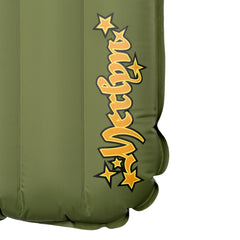 Close-up detail of the olive green Yucca Merlyn inflatable surf mat showing the yellow Merlyn script logo with star accents along the lower edge. Vertical air chambers and welded seams highlight the mat’s inflatable construction and signature branding.