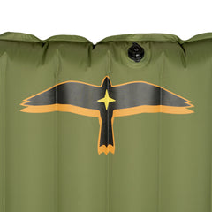 Close-up detail of the olive green Yucca Merlyn inflatable surf mat showing the black and gold bird logo near the top and the inflation valve above it. Vertical air chambers and smooth welded construction highlight the mat’s durable inflatable design.