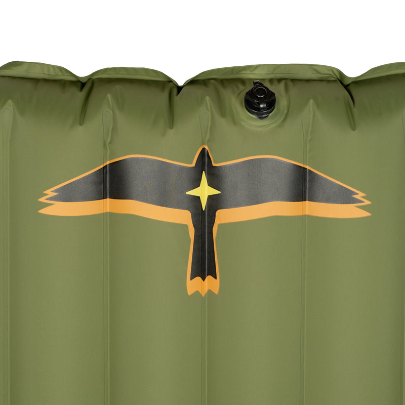 Close-up detail of the olive green Yucca Merlyn inflatable surf mat showing the black and gold bird logo near the top and the inflation valve above it. Vertical air chambers and smooth welded construction highlight the mat’s durable inflatable design.