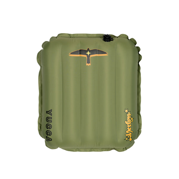 Olive green Yucca Mini Merlyn inflatable surf mat shown flat against a light gray background. Features vertical air chambers, black and gold bird logo at the top, black Yucca logo along the side, and yellow script Merlyn logo near the bottom. 