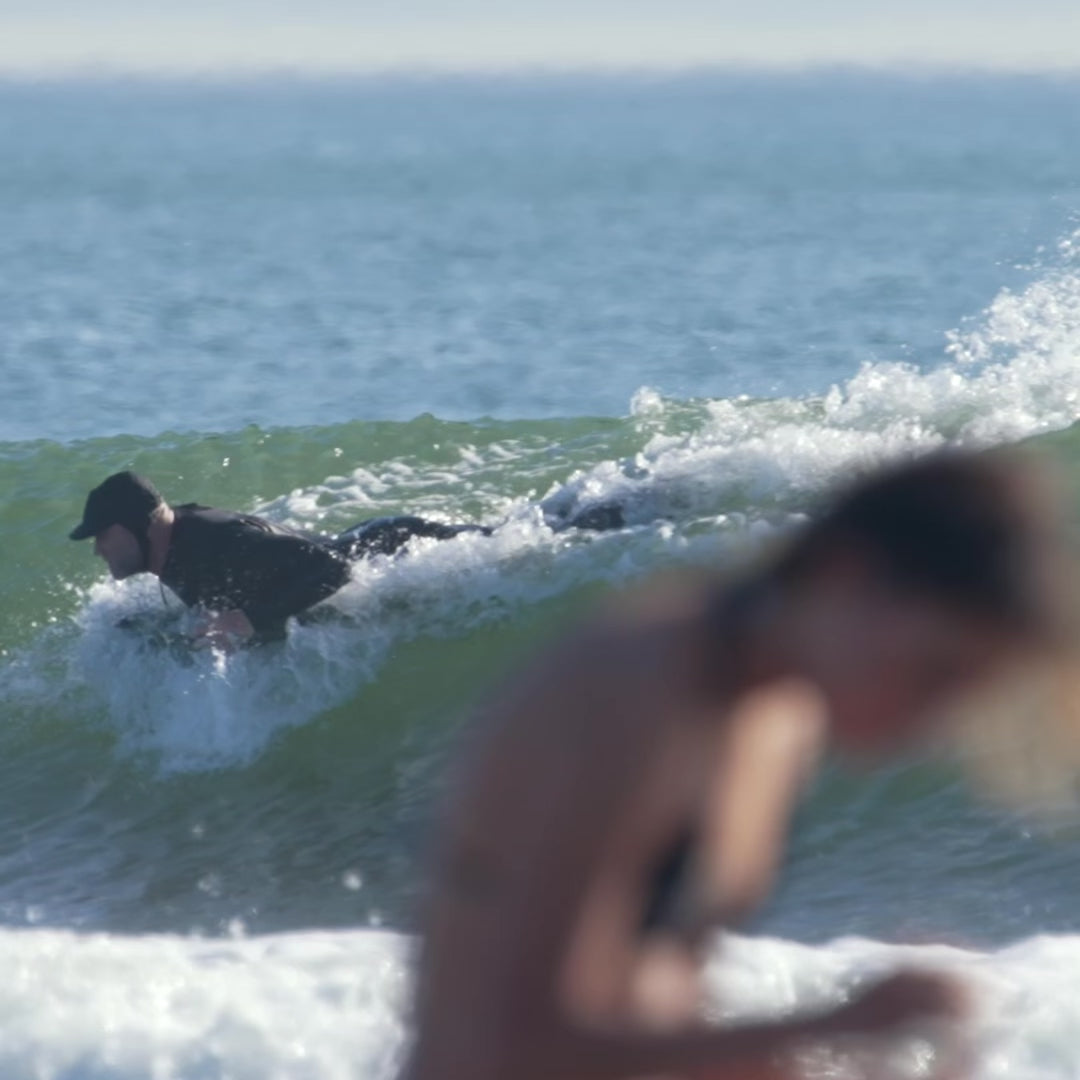 Video of the surf mat in use in a wave by a man in a wetsuit