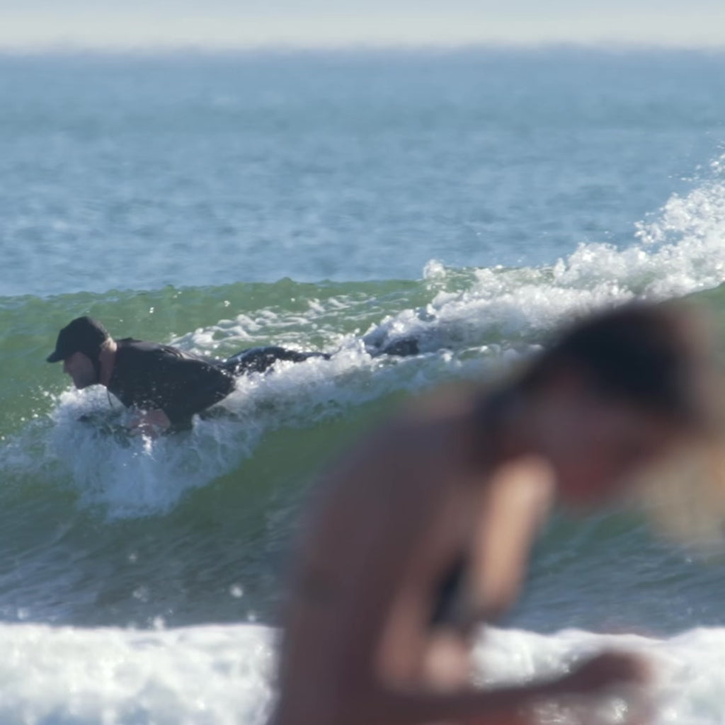 Video of the surf mat in use in a wave by a man in a wetsuit